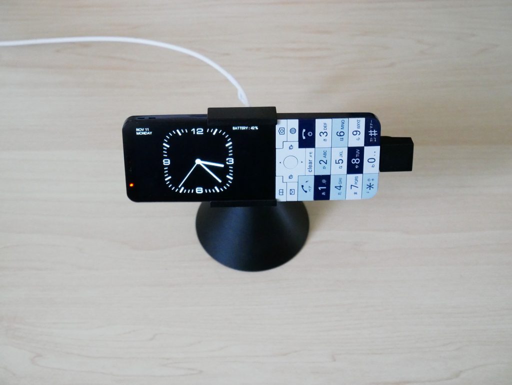 卓上ホルダに載せて充電中のINFOBAR xv